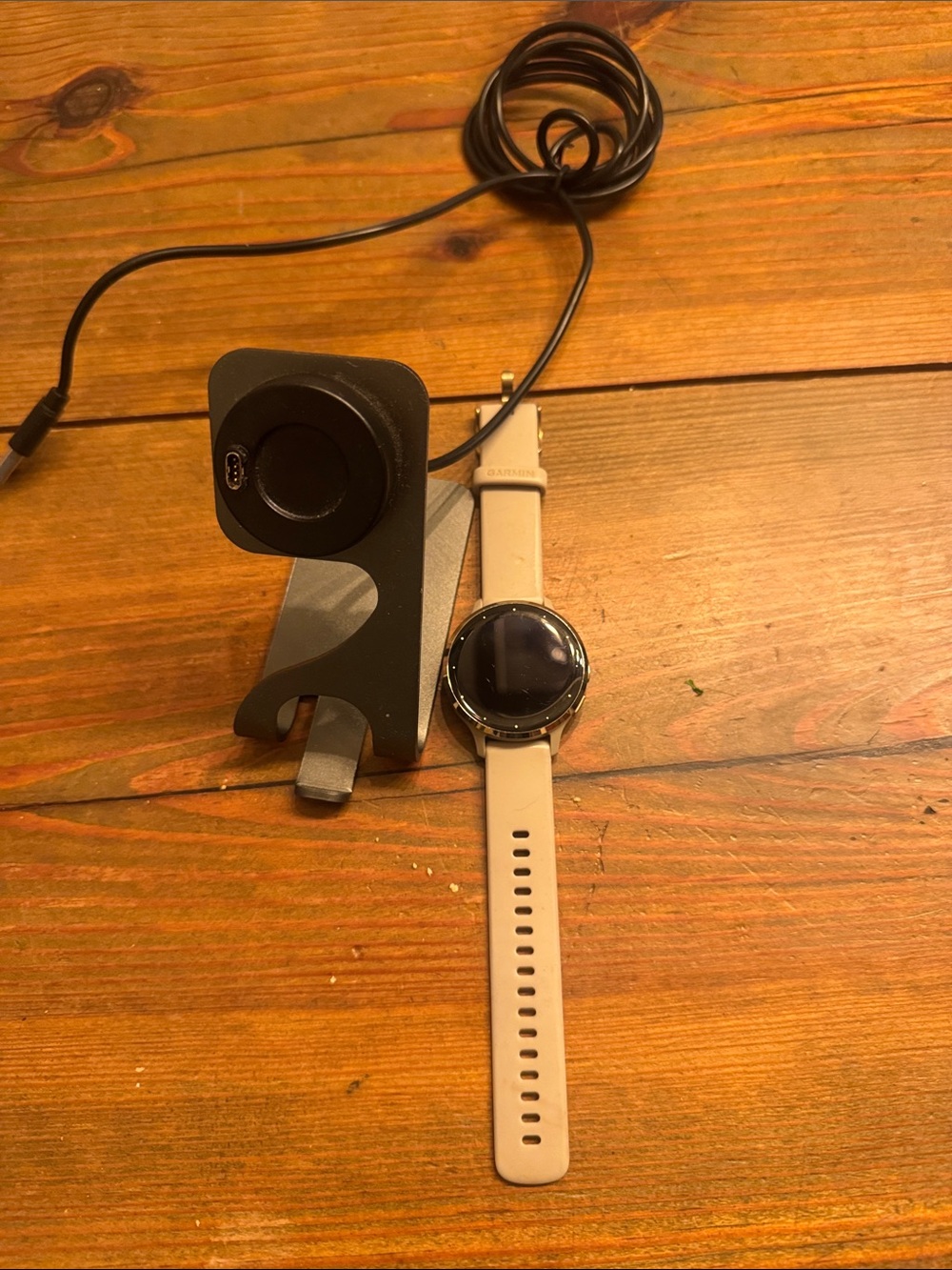 Garmin Smartwatch with Beige Band and Black Charger Stand